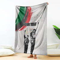 Light gray personalized blanket with green-red brush stripe and standing black-and-white figures