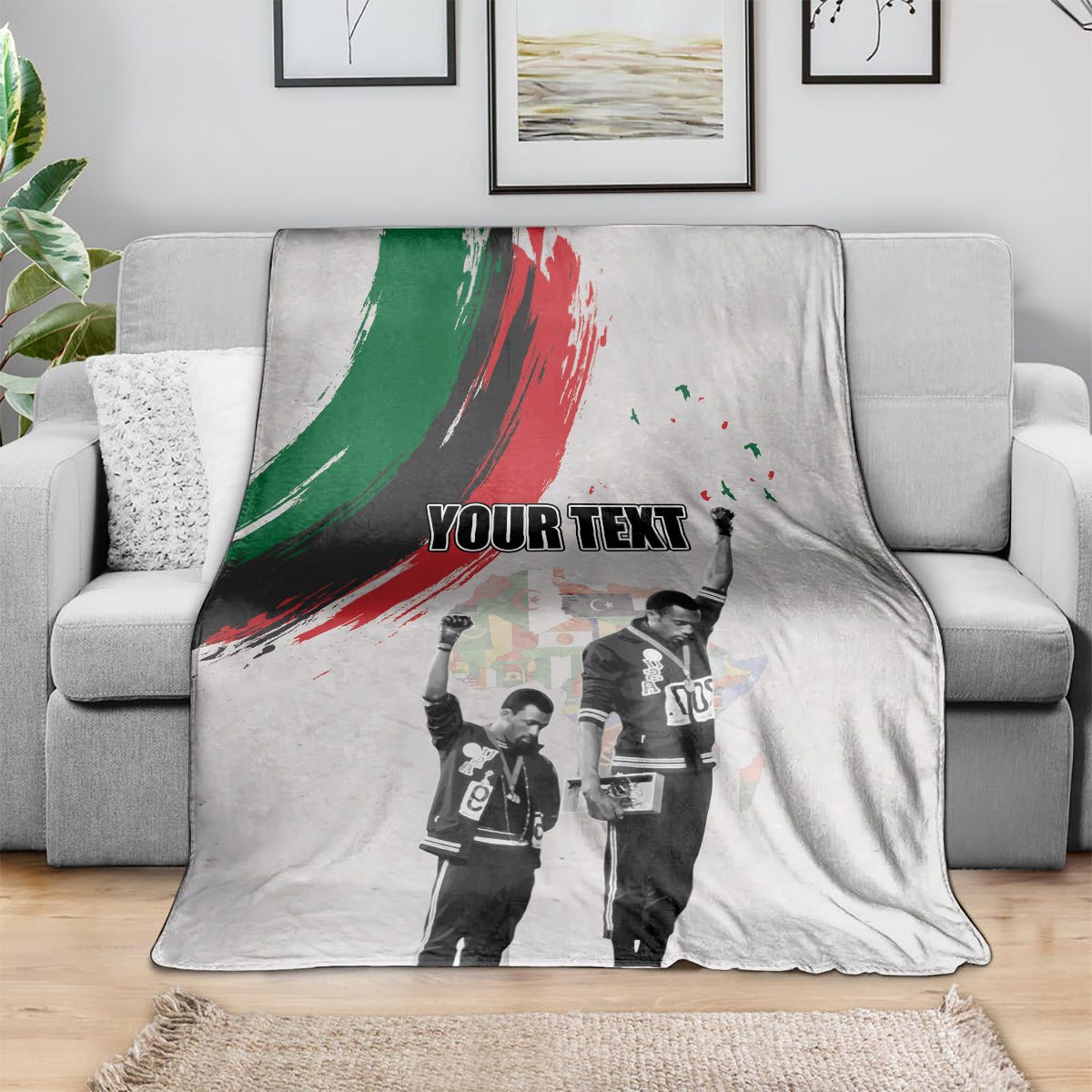 Light gray personalized blanket draped on sofa with green-red brush stripe and “YOUR TEXT”