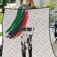 White quilt with green and red brushstroke, black-and-white figures, and 'YOUR TEXT'