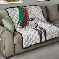 White quilt on gray sofa with green/red brushstroke, black-and-white figures, and 'YOUR TEXT'
