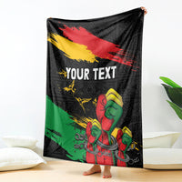 Black personalized blanket with 'YOUR TEXT' and raised-fist print, red-yellow-green diagonal stripes