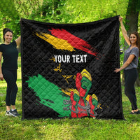 Black quilt spread outdoors with red-yellow diagonal bands, green section, raised fist, “YOUR TEXT”