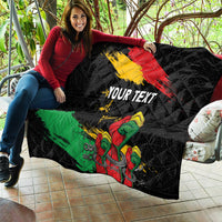 Black quilt held up showing red-yellow diagonal stripe, green band, raised fist, “YOUR TEXT”