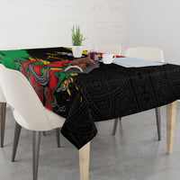 Black tablecloth with colorful raised fist artwork and repeating ornate motifs, draped on table.