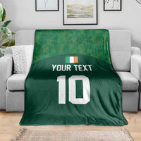 Green rugby-style throw blanket on a sofa, printed 'YOUR TEXT' and white '10'