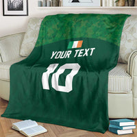 Green rugby blanket on a couch with 'YOUR TEXT' and white '10' center print