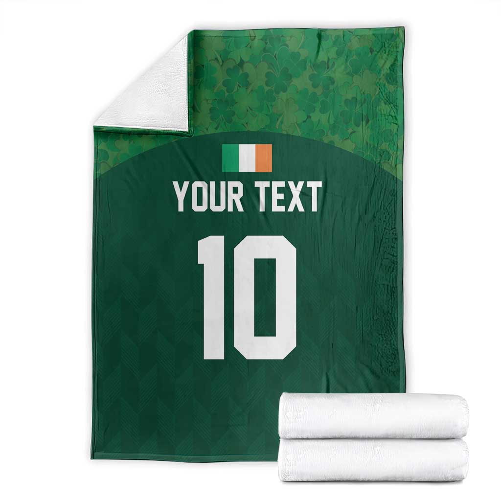 Green rugby-style blanket with 'YOUR TEXT' and white '10', folded with white towels