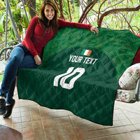 Green quilt with diamond stitching, custom text and number 10, laid on sofa