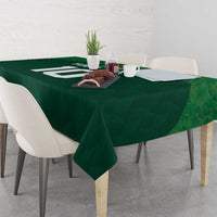 Green shamrock-pattern tablecloth on a dining table with chairs and centerpiece