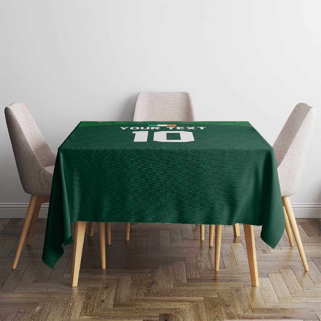 Green shamrock-pattern tablecloth on a square table with chairs, centered view