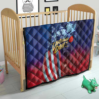 Blue and red quilt on baby crib featuring Veterans Day soldier, stars, and flag stripes