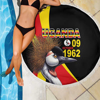 Round black beach blanket with crowned crane and Uganda flag stripes; shows 09 Oct 1962