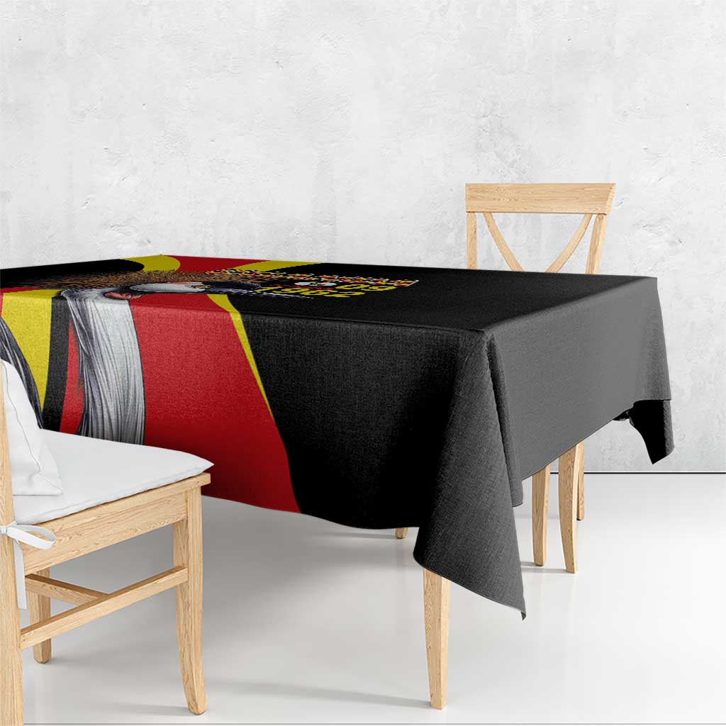 Black tablecloth draped over dining table with Uganda flag stripe and crowned crane artwork
