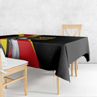 Black tablecloth draped over dining table with Uganda flag stripe and crowned crane artwork