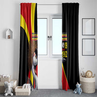 Black window curtain with crowned crane and Uganda “09 1962” graphic beside doorway
