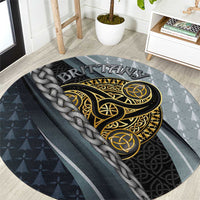 Round grey carpet with gold Celtic triskele emblem and braided knot trim.