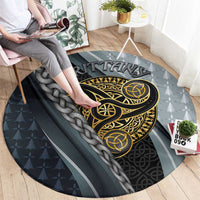 Round grey carpet with large gold Celtic emblem, braided knot border, sporty stripes.