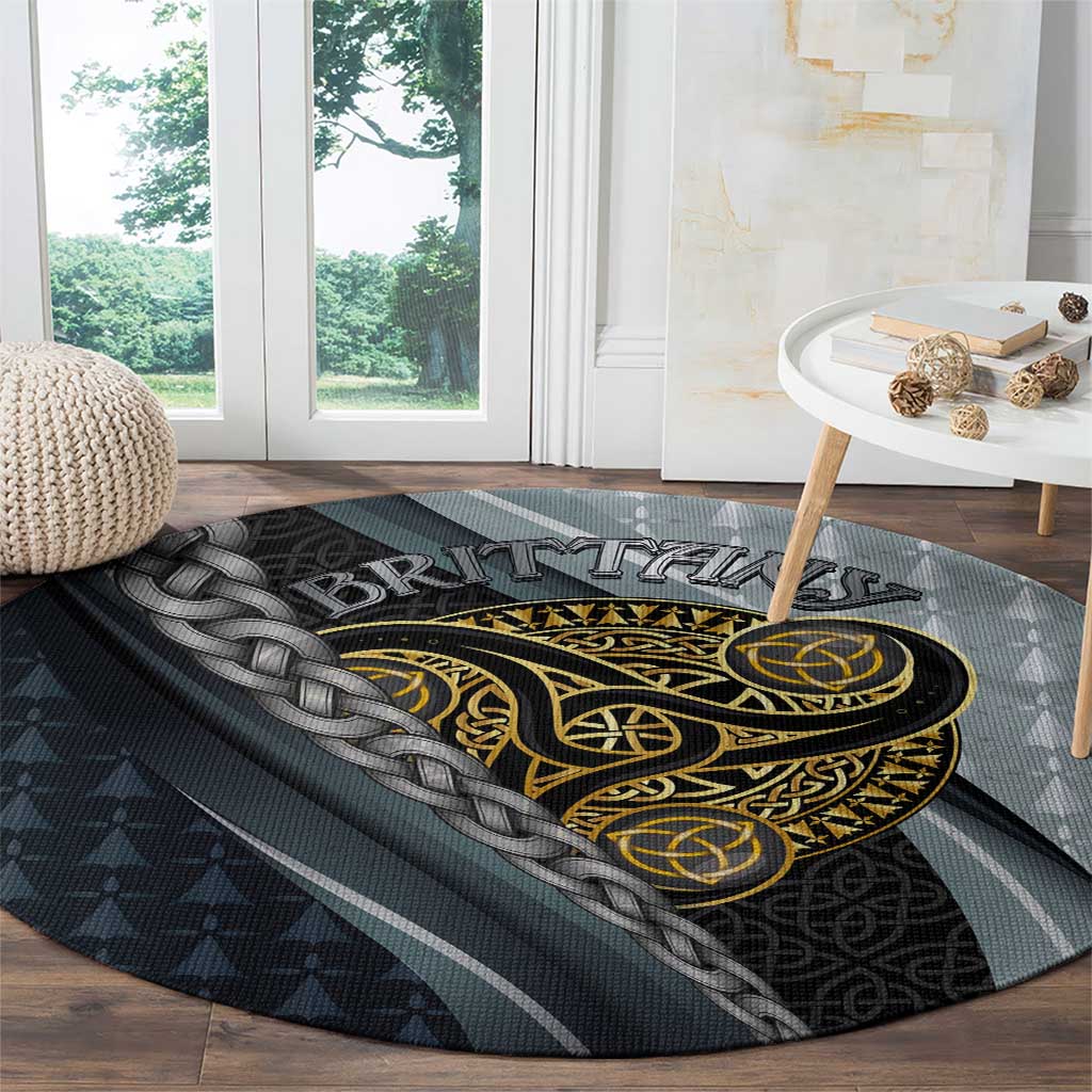 Round grey carpet with gold and black Celtic emblem and braided knot detail along edge.