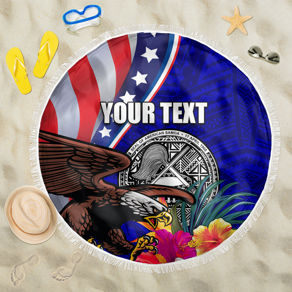 Round beach blanket with blue/red eagle and seal badge, hibiscus flowers, white fringe.