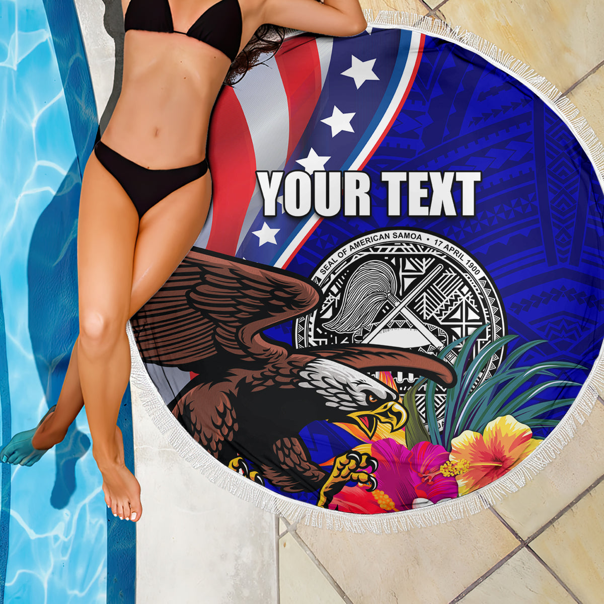 Round beach blanket with blue/red eagle and seal badge, hibiscus flowers, white fringed edge.