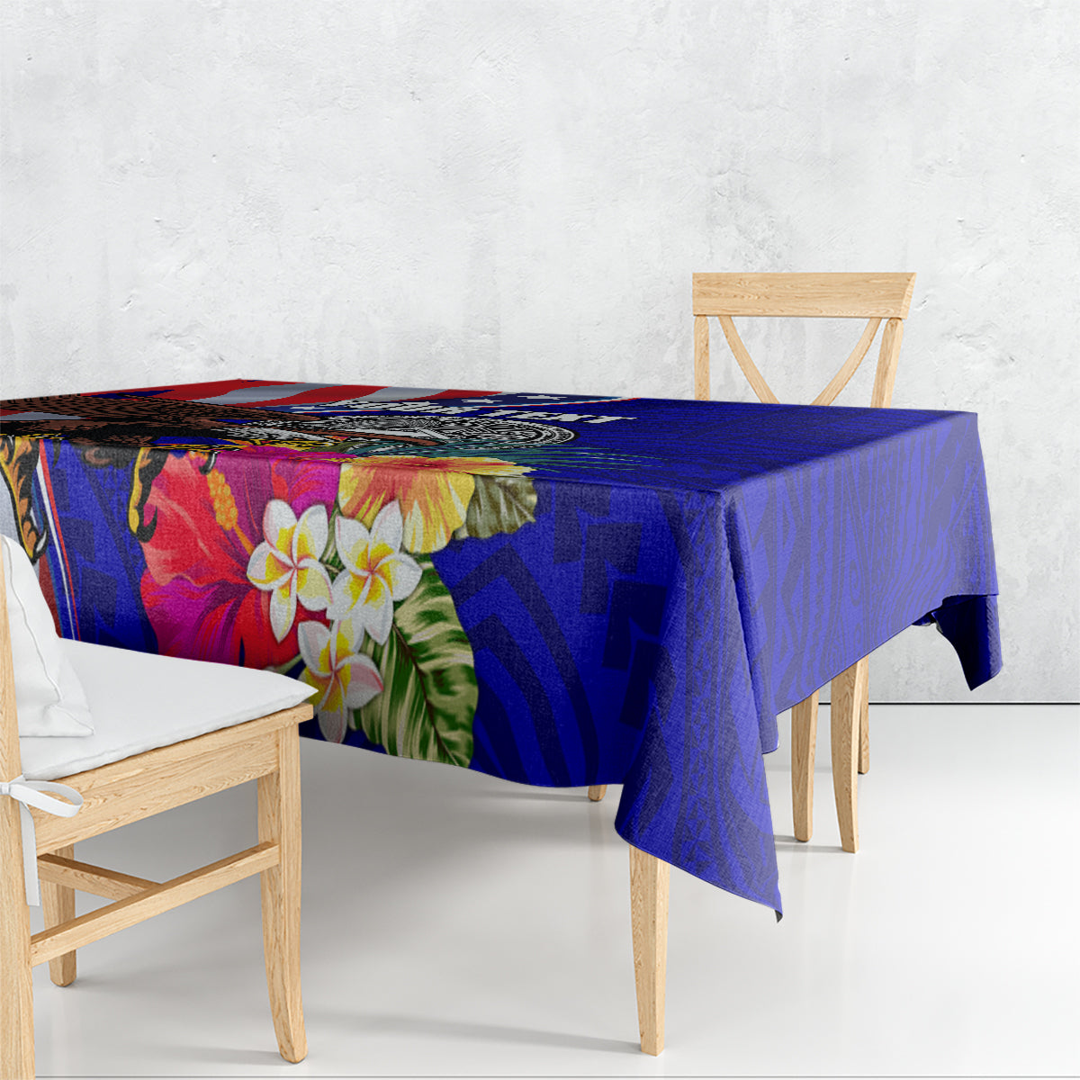 Blue Polynesian-style tablecloth with hibiscus flowers and geometric pattern, draped on table