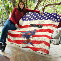 Quilt held outdoors with American flag pattern, “Champion” lettering, and stylized bird graphic