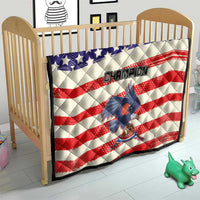 Quilt on crib with American flag stars-and-stripes pattern and “Champion” bird graphic