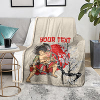 Beige personalized blanket on floor with samurai warrior, red “Your Text”, and blossom tree