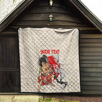 Beige quilt hanging on wall, diamond quilting with red “YOUR TEXT” and samurai blossom scene.
