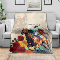White horse racing anniversary blanket draped over sofa, featuring “Anniversary 151st,” roses, riders