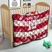 Red rugby quilt with cherry blossoms, 'YOUR TEXT' and number 10 on a child bed