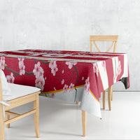 Red floral tablecloth with cherry blossoms and gold diagonal stripe, shown from the side