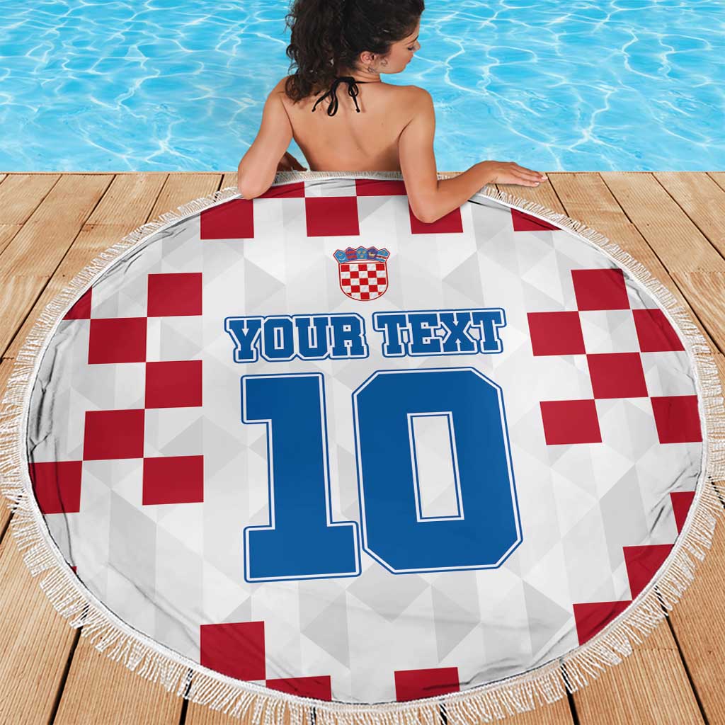Round Croatia beach blanket on wooden deck, red check design with number 10 and fringed edge