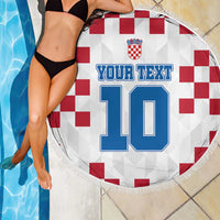 Round Croatia beach blanket over pool tiles, red check flag with blue 10 print and fringe