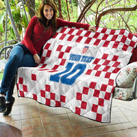 Custom quilt held on patio: white with red check pattern and blue number 10