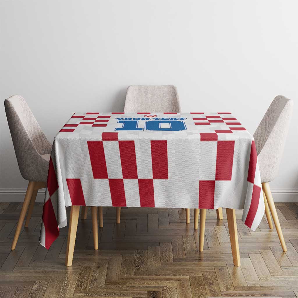 White tablecloth with red checkerboard design and blue emblem on dining table