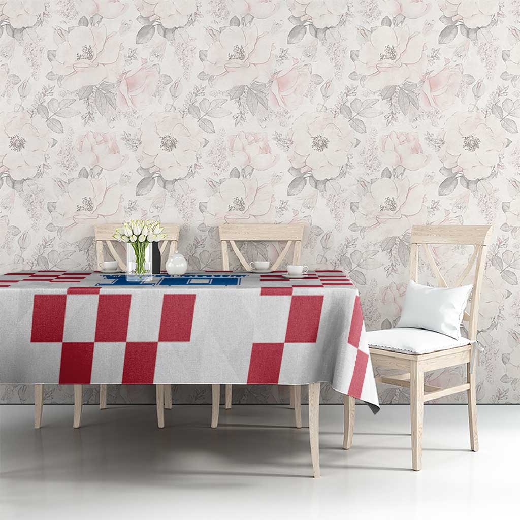 White tablecloth with red checkered design on dining table with vase flowers