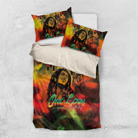 Reggae-themed bedding set on white bed, duvet with portrait and One Love text, two pillows