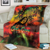 Reggae-themed throw blanket on cream couch, reggae legend artwork with 'One Love' glow text