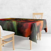 Reggae-themed tablecloth with red, green and black abstract artwork draped over wooden table