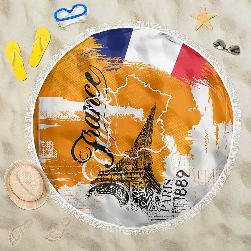 Round beach blanket with orange and white France typography, Eiffel Tower graphic, fringed edge
