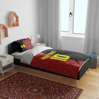 Red and black duvet cover on bed with two matching pillow shams and yellow number 10