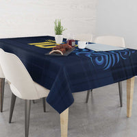 Navy blue tablecloth with yellow emblem and blue swirl pattern on dining table