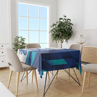 Blue and teal geometric tablecloth covering dining table with chairs