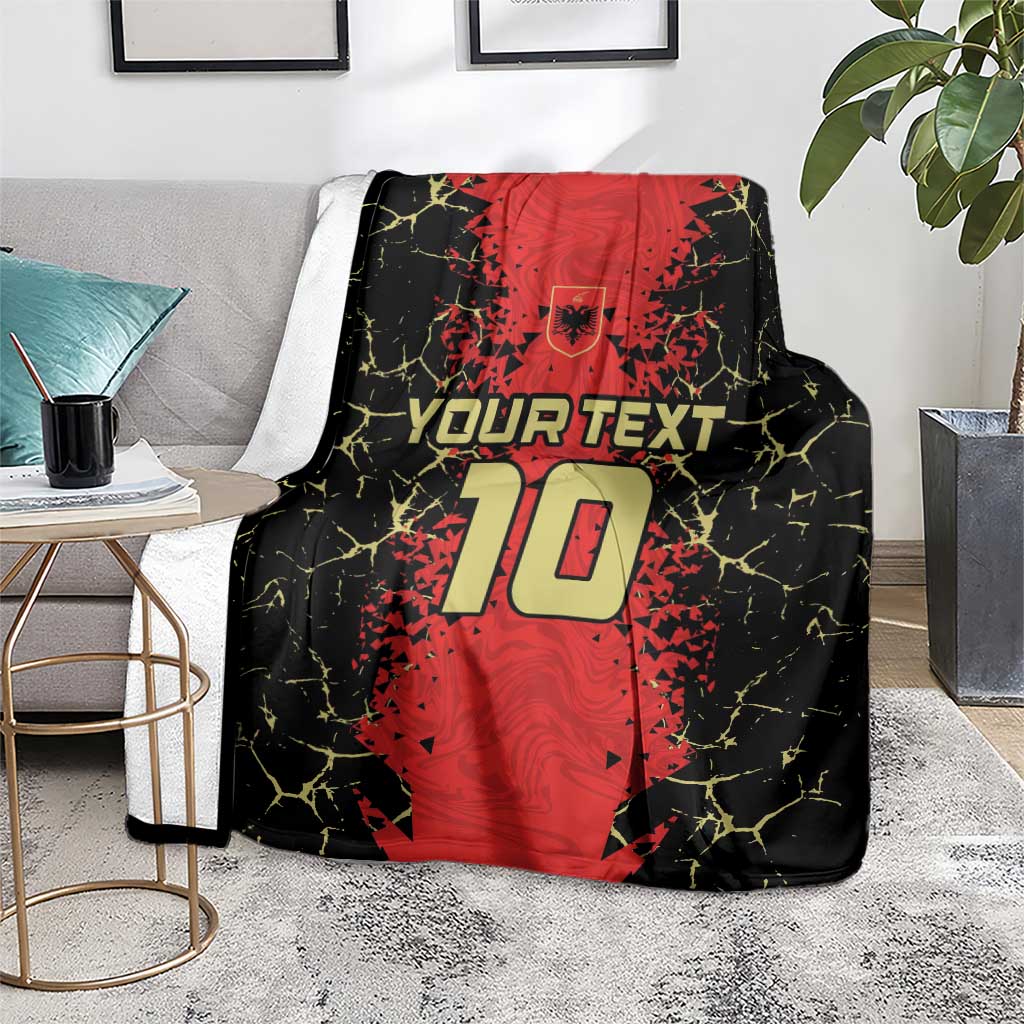Black and red custom football blanket draped over sofa with shield crest and 10