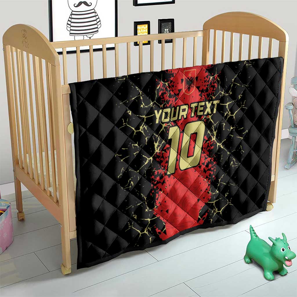 Quilt blanket in a crib with black base, red football jersey print, number 10, and “YOUR TEXT”.