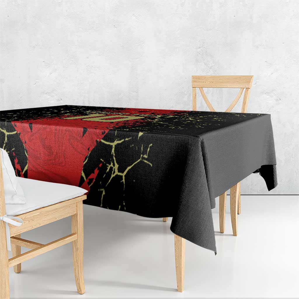 Football-themed tablecloth in black and red with yellow crackle lines, over a bench-style table