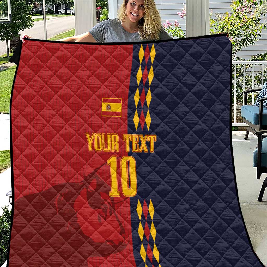 Red and navy diamond-quilt blanket with Spain crest, blue/yellow stripes and '10'.