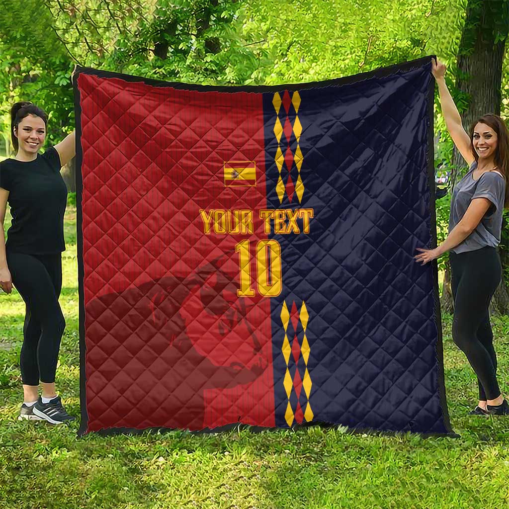 Red and navy diamond-quilt blanket with Spain crest, blue/yellow stripes and '10' on grass.