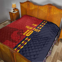 Red and navy diamond-quilt blanket with Spain crest, blue/yellow stripes, '10' on bed.